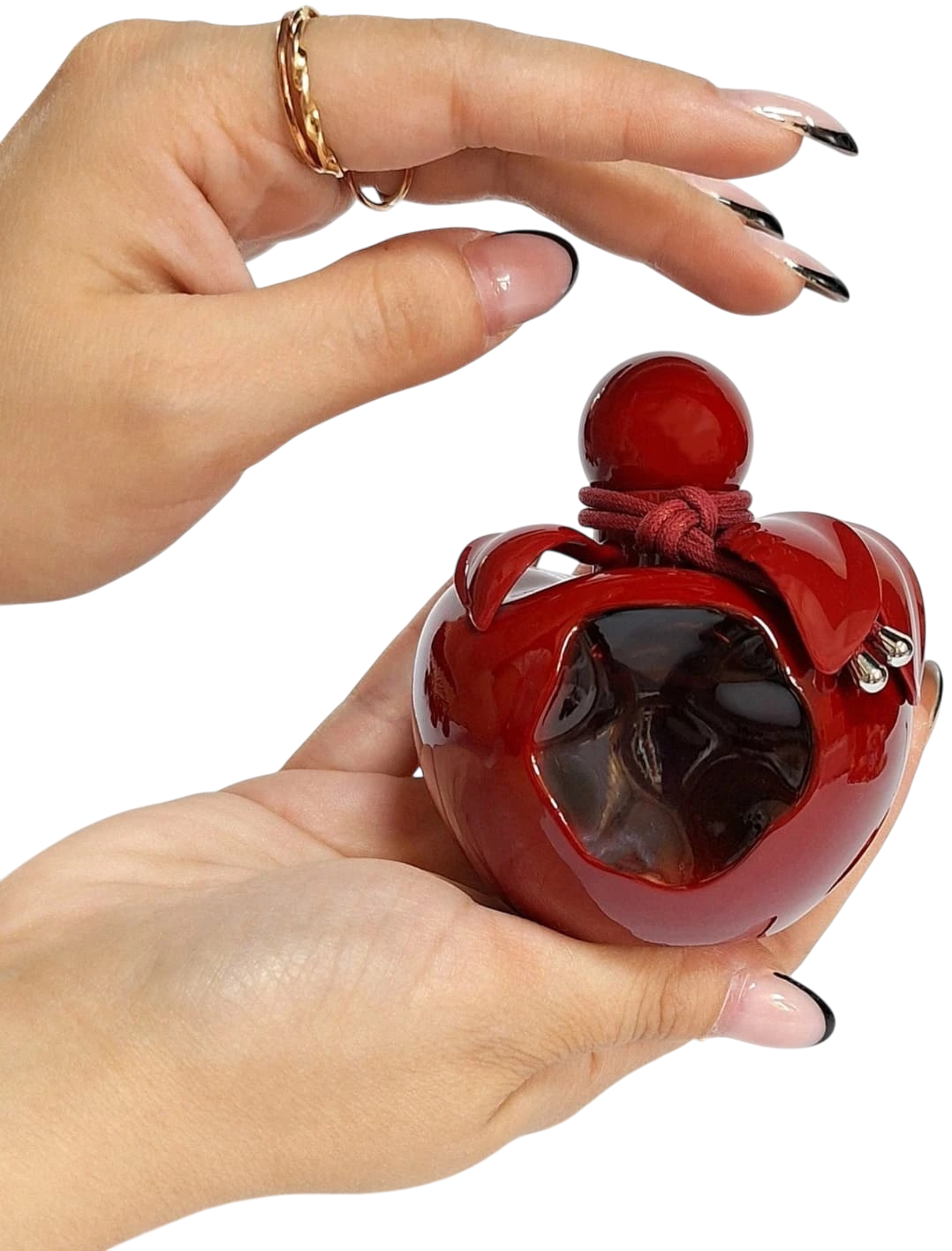 Detalhe do frasco Nina Rouge Crush ao lado de cerejas frescas