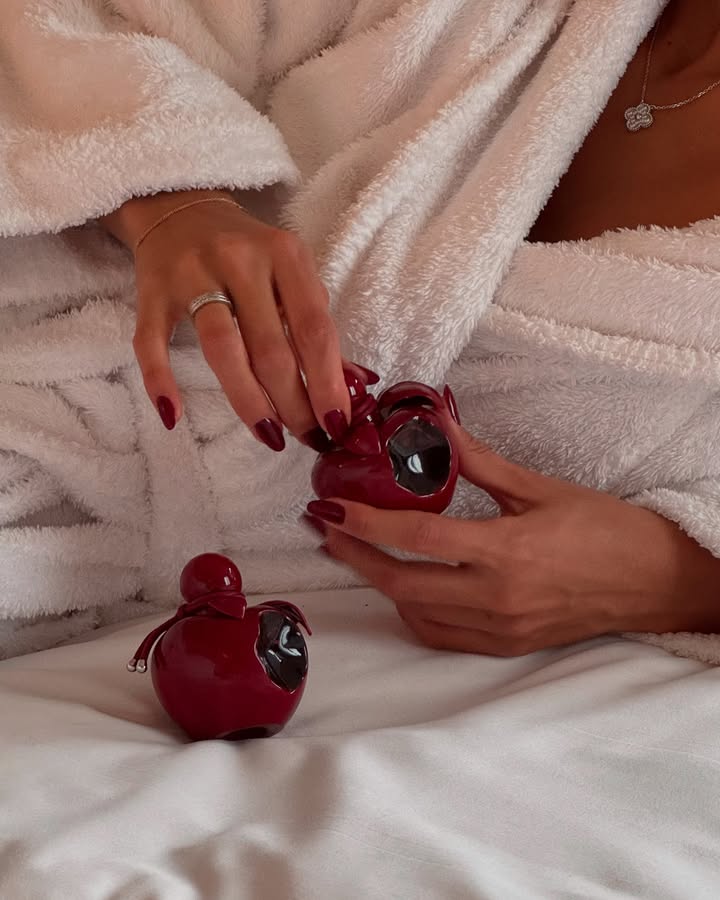 Detalhe lifestyle do frasco Nina Rouge Crush em ambiente de intimidade