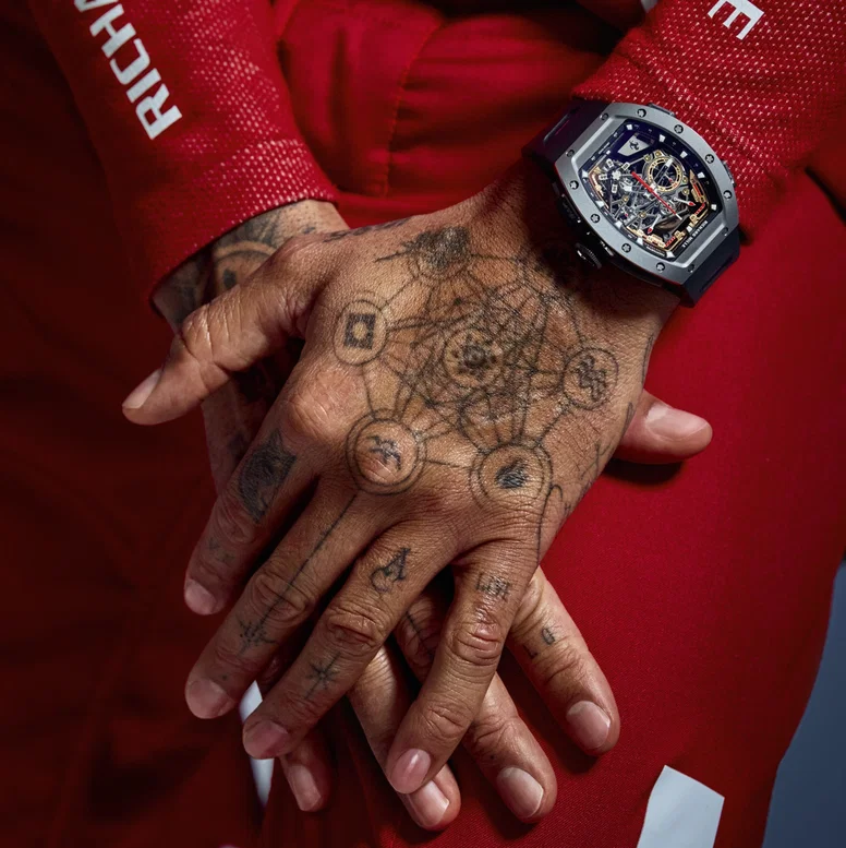 Close do Richard Mille RM 43-01 Ferrari no pulso tatuado de Lewis Hamilton, macacão vermelho da Scuderia Ferrari